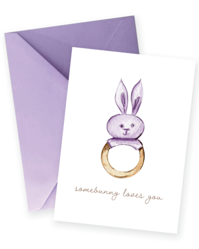 Watercolor bunny rattle new baby greeting card featuring the sentiment "somebunny loves you" and a lavender envelope.