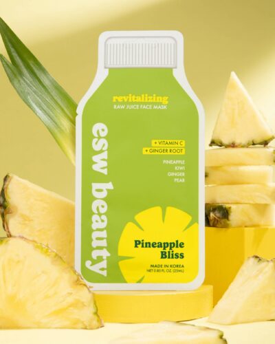 ESW Beauty Pineapple Bliss Revitalizing Raw Juice Sheet Mask styled with fresh pineapple slices on a yellow background.